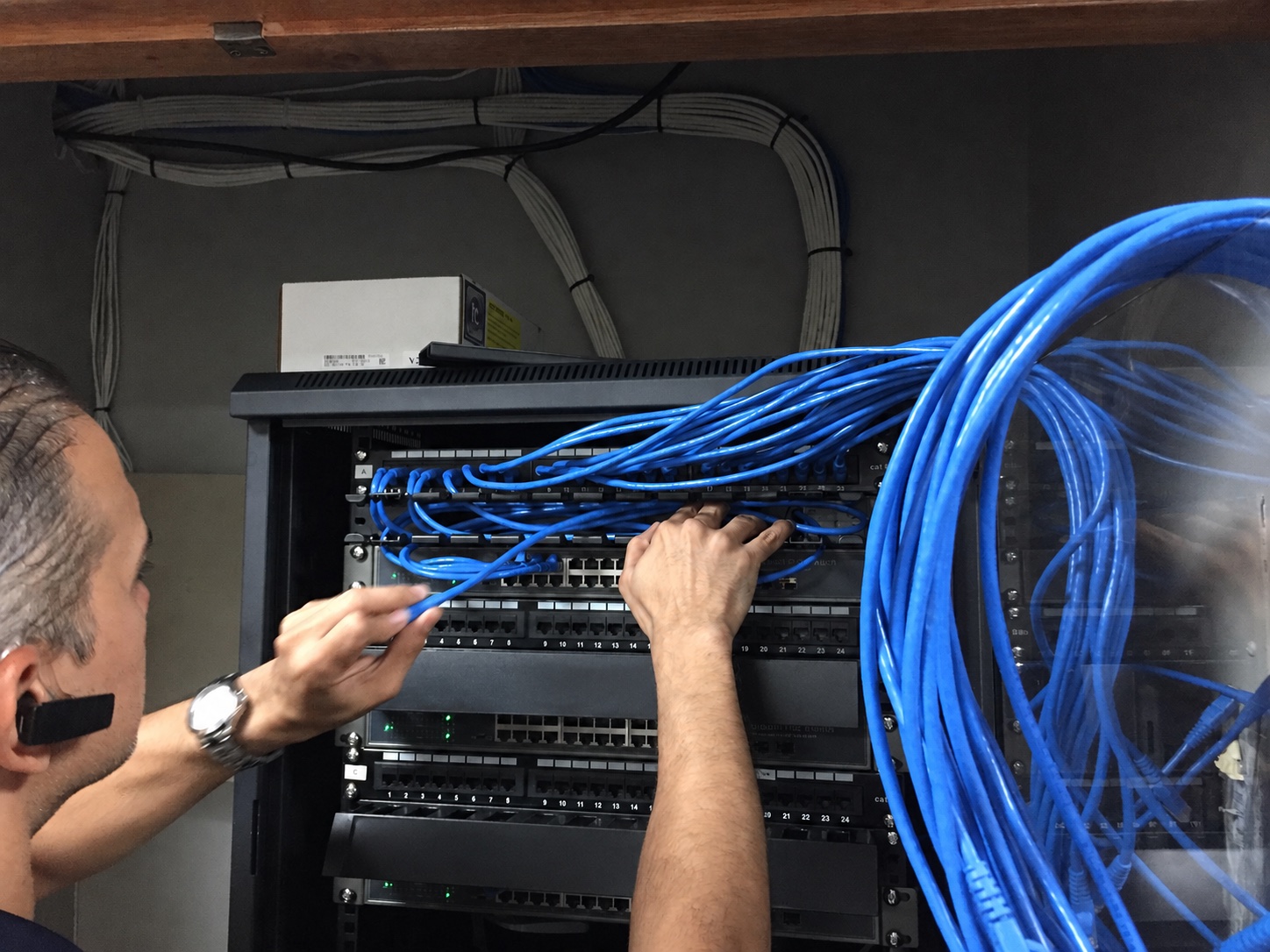 Technician organizing blue network cabling